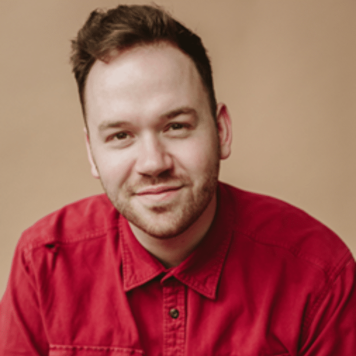 Griffin Cork with short brown hair wearing a red button-up shirt.