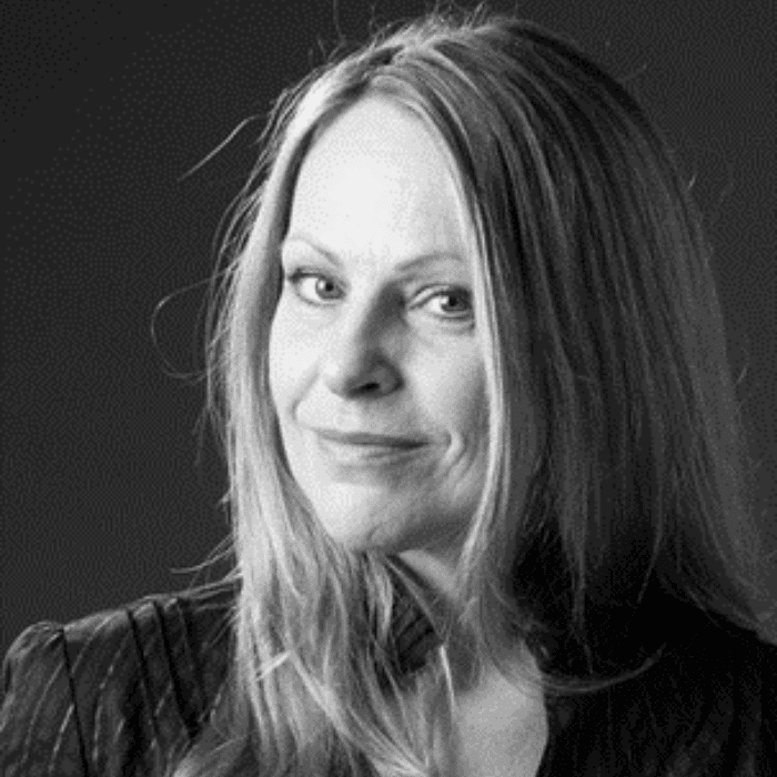 Black and white headshot of Jill Sharpe with long, light hair wearing a dark shirt.